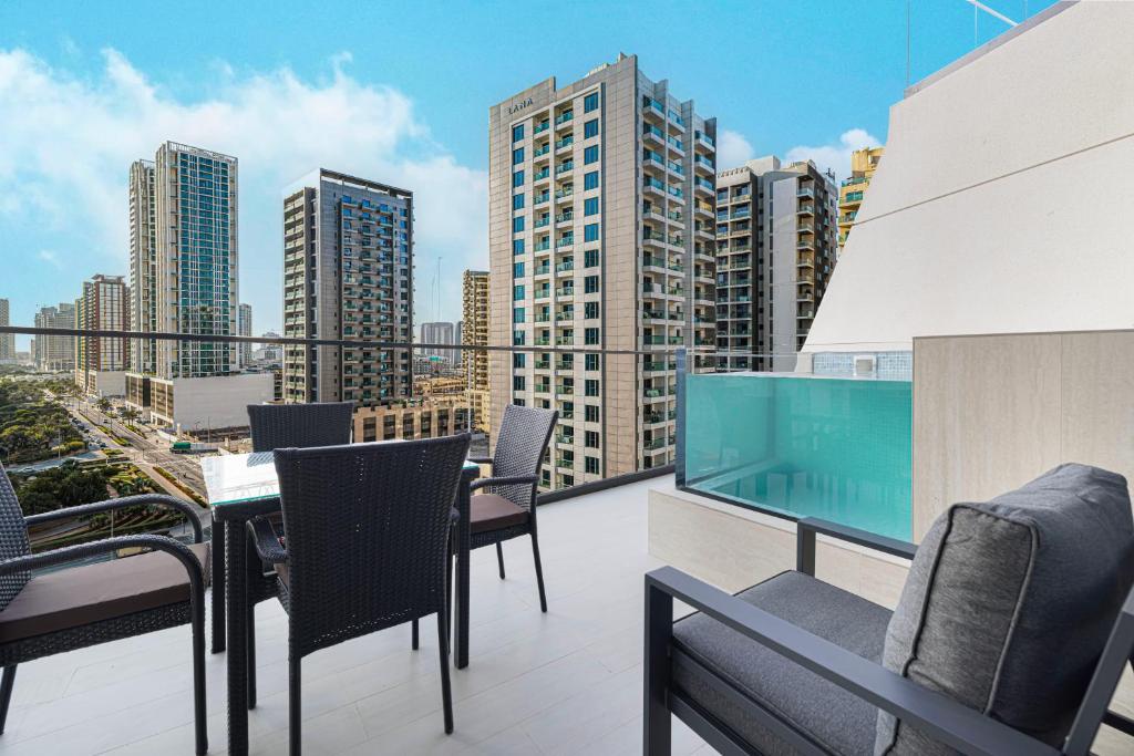 Private balcony with dining set and plunge pool overlooking the city