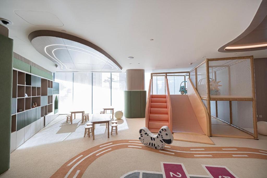 Indoor kids' playground with soft slide, climbing frame and play tables
