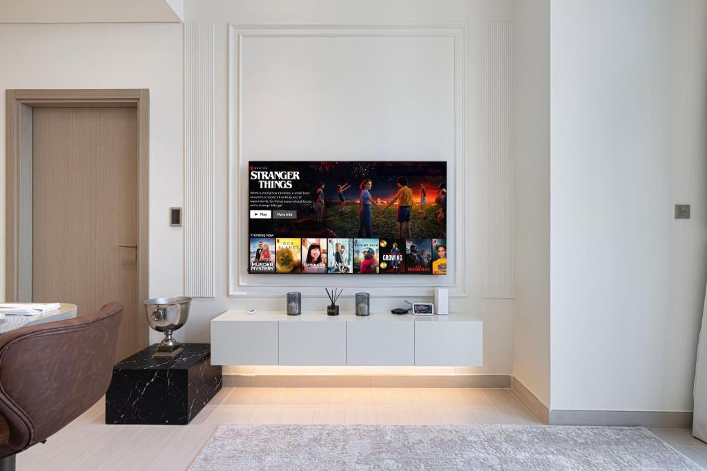 Living area media wall with floating console, smart TV and leather armchair