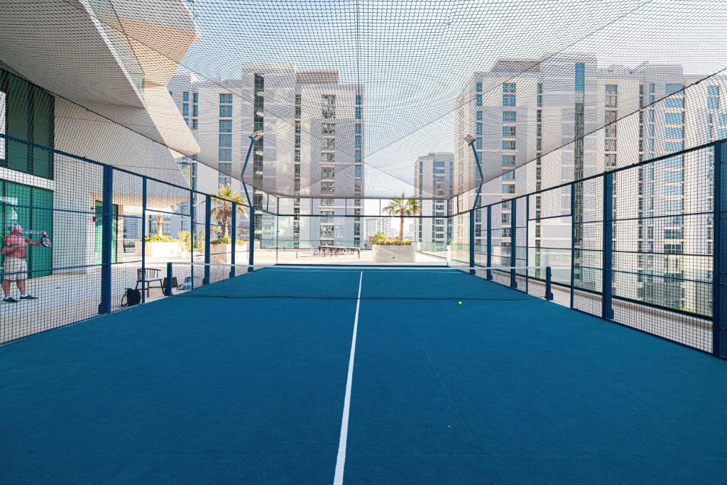 Rooftop padel court enclosed in netting with city views