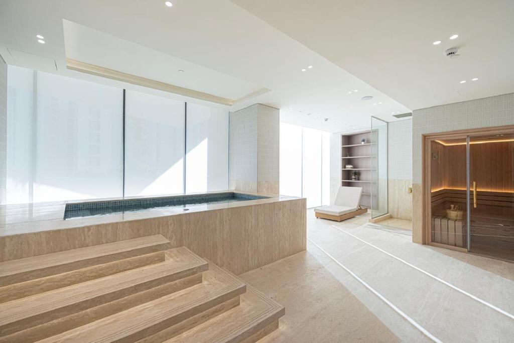 Indoor spa with plunge pool and sauna beside floor-to-ceiling windows
